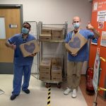 Masked ENT workers at Peterborough Hospital and head consultant Mr Amen receive their surprise Delicious Deliveries Hampers
